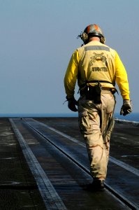 US Navy 100118-N-3038W-444 Lt. Samuel Kesler inspects a catapult track before flight operations aboard the aircraft carrier USS Nimitz (CVN 68)