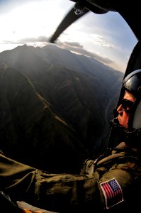 US Navy 100118-N-6006S-041 An air crew member surveys the Haitian geography before landing and dropping off supplies