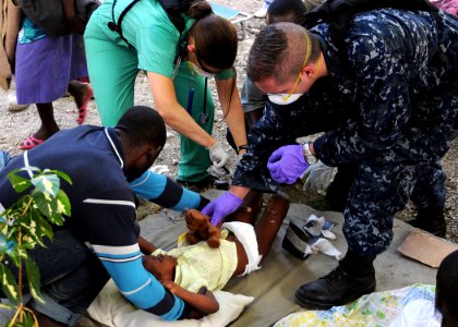 US Navy 100119-N-6247V-624 Lt. Kristina Rogish, a flight surgeon assigned to Carrier Air Wing (CVW) 17 treats an injured child while Hospital Corpsman 1st Class Adam Kishman
