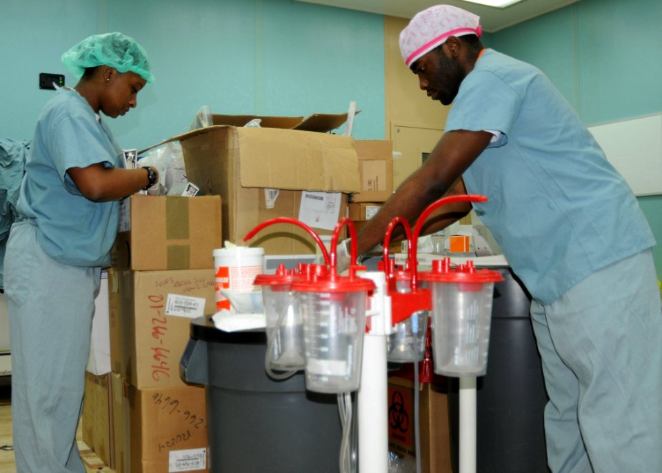 US Navy 100118-N-6410J-028 Hospital Corpsman 3rd Class Crystal Whiteside and Hospitalman Leonard Brown organize medical supplies in an operating room aboard the Military Sealift Command hospital ship USNS Comfort (T-AH 20) to s