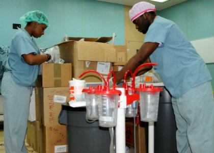 US Navy 100118-N-6410J-028 Hospital Corpsman 3rd Class Crystal Whiteside and Hospitalman Leonard Brown organize medical supplies in an operating room aboard the Military Sealift Command hospital ship USNS Comfort (T-AH 20) to s photo