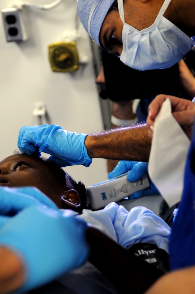 US Navy 100118-N-8878B-090 Dr. Sanjay Gupta, a CNN medical correspondent and practicing neurosurgeon, prepares a 12-year-old Haitian girl with a severe head injury for surgery aboard the Nimitz-class aircraft carrier USS Carl V