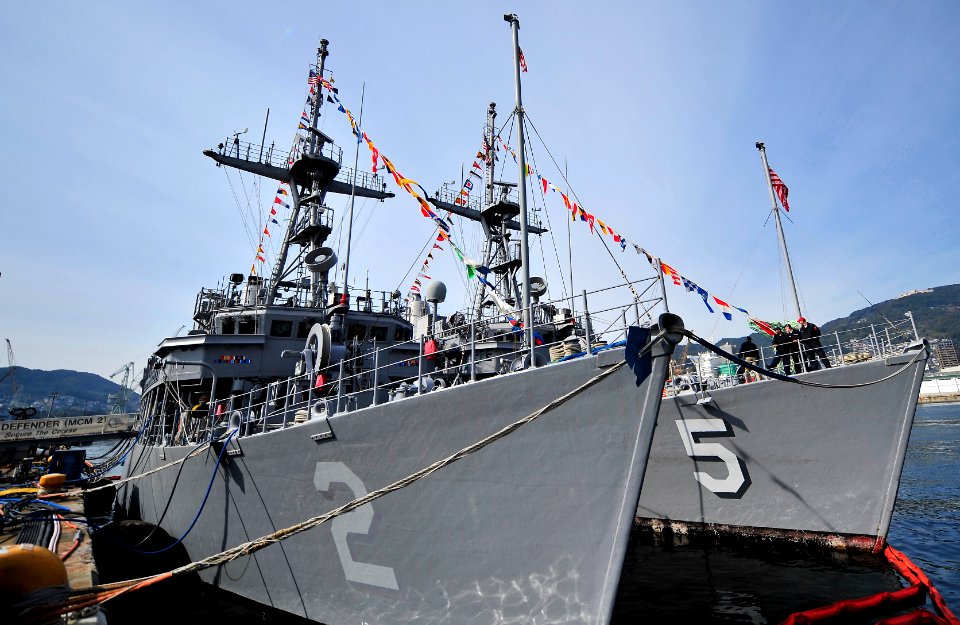 US Navy 100119-N-0807W-010 The mine countermeasures ships USS Guardian (MCM 5) and USS Defender (MCM 2) are dressed out while moored abreast in Sasebo Harbor t