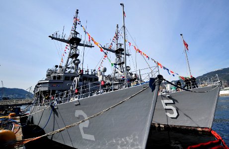 US Navy 100119-N-0807W-010 The mine countermeasures ships USS Guardian (MCM 5) and USS Defender (MCM 2) are dressed out while moored abreast in Sasebo Harbor t