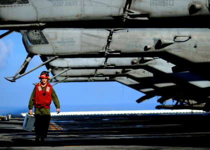 US Navy 100118-N-5345W-032 Lance Cpl. Timothy Smith, assigned to the Sabers of Marine Light Attack Helicopter Squadron (HMLA) 467 crosses the flight deck unde