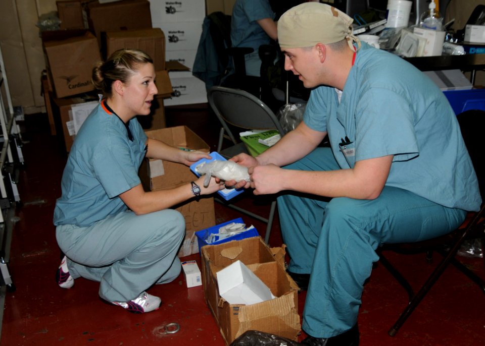 US Navy 100118-N-6410J-023 Hospital Corpsman 3rd Class Bridgette Short, left, and Hospital Corpsman 3rd Class Mathew Vinyard inventory medical supplies aboard the Military Sealift Command hospital ship USNS Comfort (T-AH 20) photo