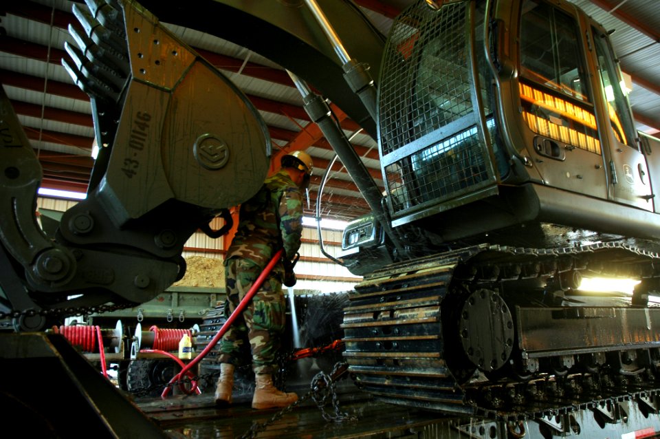US Navy 100118-N-7367K-002 A Seabee assigned to Naval Mobile Construction Battalion (NMCB) 7 washes an excavator before shipment to Haiti