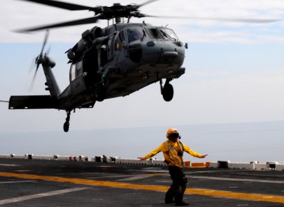 US Navy 100119-N-7508R-016 A landing signal enlisted (LSE) directs an MH-60S Sea Hawk helicopter assigned to Helicopter Sea Squadron (HSC) 22 to lift off from the multi-purpose amphibious assault ship USS Bataan (LHD 5) photo