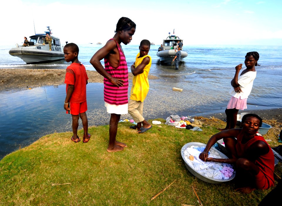 US Navy 100119-N-5345W-032 Haitian citizens watch as Sailors and Marines assigned to the Bataan Amphibious Relief Mission begin to come ashore to set up an operating base at the New Hope Mission at Bonel, Haiti