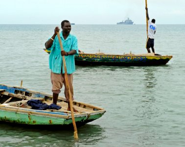 US Navy 100119-N-5345W-124 Haitian fishermen navigate their boats away from the designated landing area as U.S. Navy and Marine Corps relief forces prepare to bring landing craft
