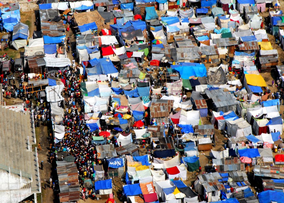 US Navy 100120-N-3165S-275 Haitians gather on the streets of one of the many tent cities occupying the area of Leogane