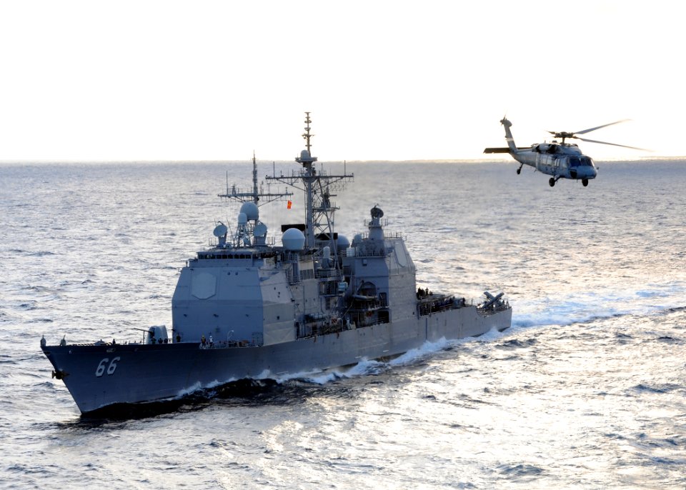 US Navy 100119-N-4236E-168 The guided-missile cruiser USS Hue City (CG 66) prepares for a replenishment at sea while an MH-60S Sea Hawk helicopter