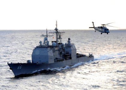 US Navy 100119-N-4236E-168 The guided-missile cruiser USS Hue City (CG 66) prepares for a replenishment at sea while an MH-60S Sea Hawk helicopter