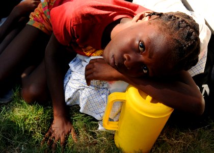 US Navy 100119-N-6247V-237 A Haitian girl rests on a jug she filled with water from a spigot at the Killick Haitian Coast Guard Clinic in Carrefour, Haiti