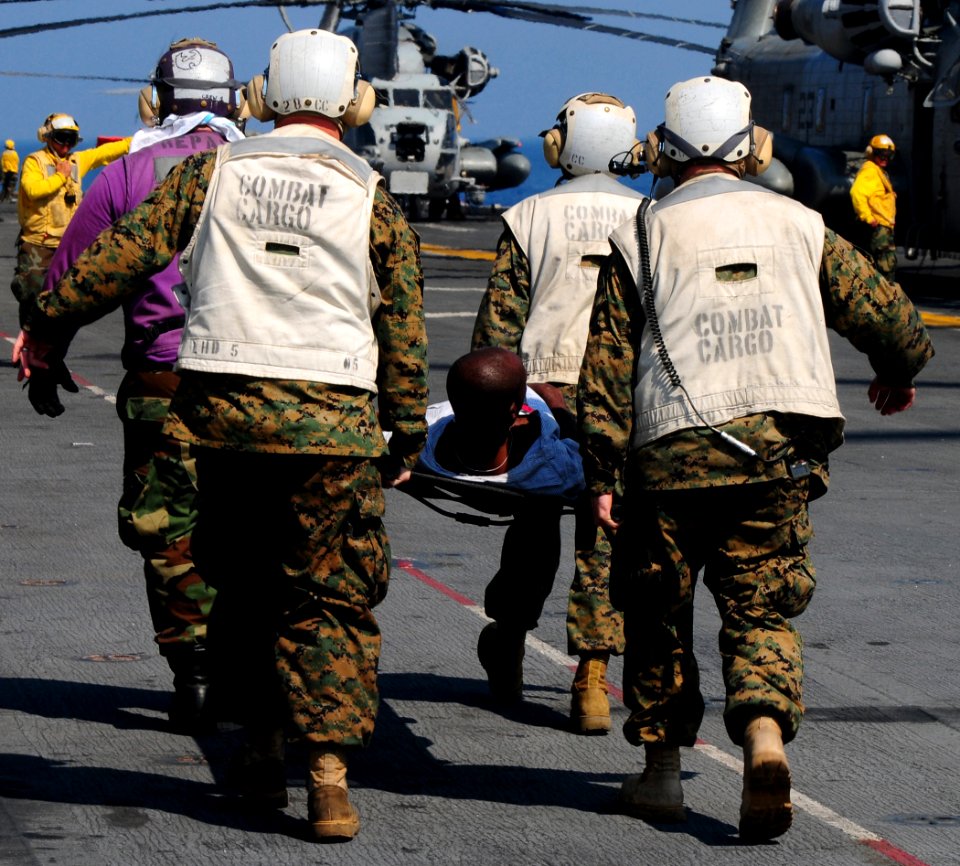 US Navy 100120-N-7508R-099 Marines aboard USS Bataan (LHD 5) carry a Haitian man to the ship's flight deck triage for immediate medical treatment