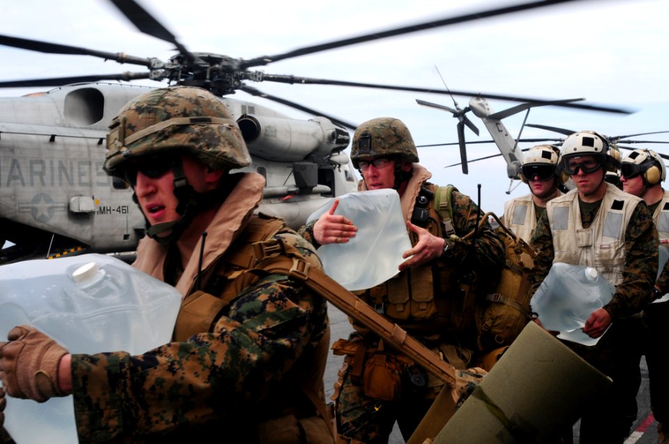 US Navy 100119-N-7508R-040 Marines carry bottles of water to load onto a CH-53E Super Stallion helicopter aboard USS Bataan (LHD 5)
