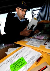 US Navy 100120-N-6233H-009 Logistics Specialist 1st Class Carlos Lopez processes inbound correspondence aboard the aircraft carrier USS George Washington (CVN 73