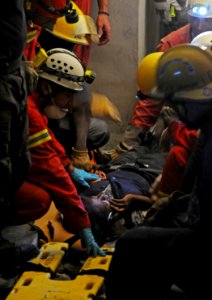 US Navy 100119-N-8878B-767 Search and Rescue teams rescue Hottline Lozoma, a 25-year-old Haitian woman, who was trapped in rubble for eight days photo
