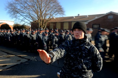 US Navy 100120-N-7090S-931 A Sailor acts as a road guard as the students march to their weekly general military training at the Basic Enlisted Submarine School at Naval Submarine Base New London, Conn photo