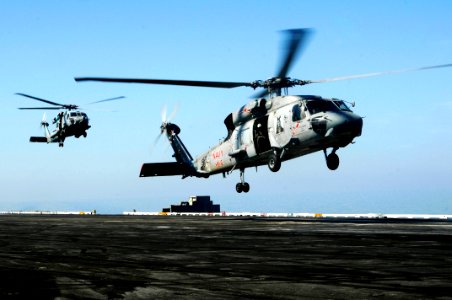 US Navy 100120-N-3038W-497 A SH-60F Sea hawk helicopter, front, and a HH-60H Sea hawk helicopter approach the flight deck of the aircraft carrier USS Nimitz (CVN 68)