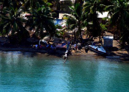 US Navy 100120-N-3165S-084 Members of a Haiti village hold up a United States flag during a reconnaissance flight to assess the damage from the 6.1 magnitude aftershock
