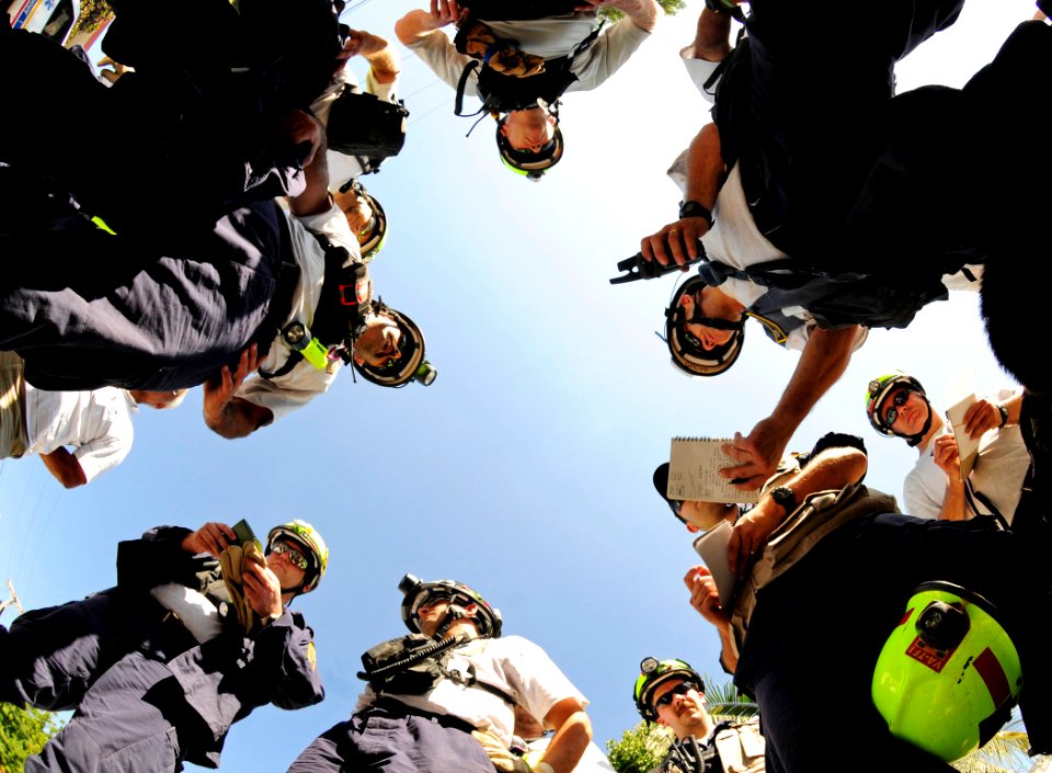 US Navy 100120-N-6006S-031 Members of the Virginia Task Force 1 Urban Search and Rescue Team, with assistance from U.S. military personnel, coordinate plans before a search and rescue mission