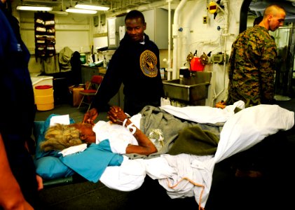 US Navy 100122-N-5345W-017 A 70-year-old Haitian woman is comforted by her son aboard USS Bataan (LHD 5)