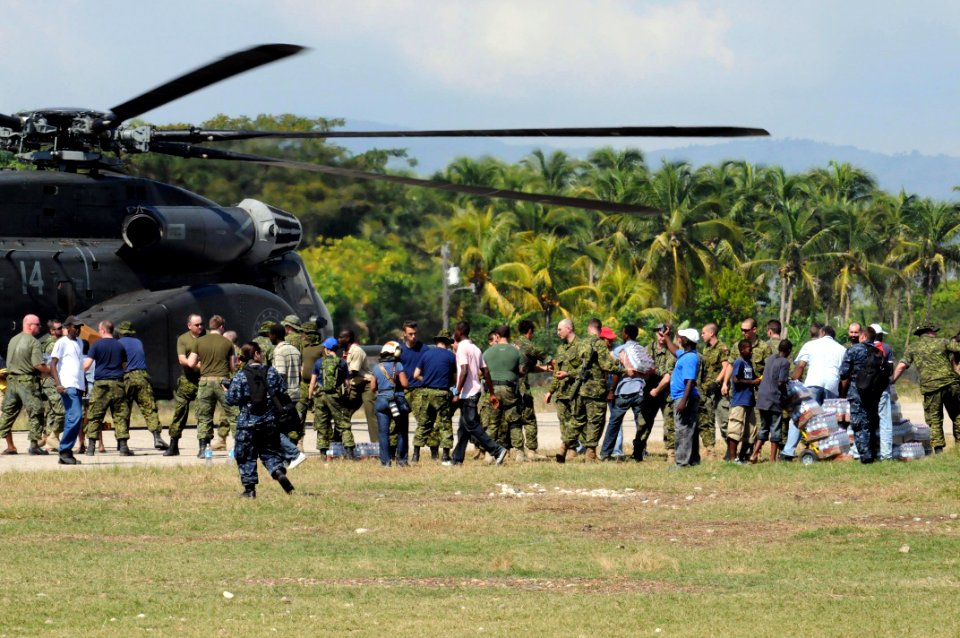 US Navy 100120-N-4995K-178 anadian Soldiers work with U.S. Navy Sailors and Haitian citizens to offload food and water from an MH-53E Sea Dragon helicopter