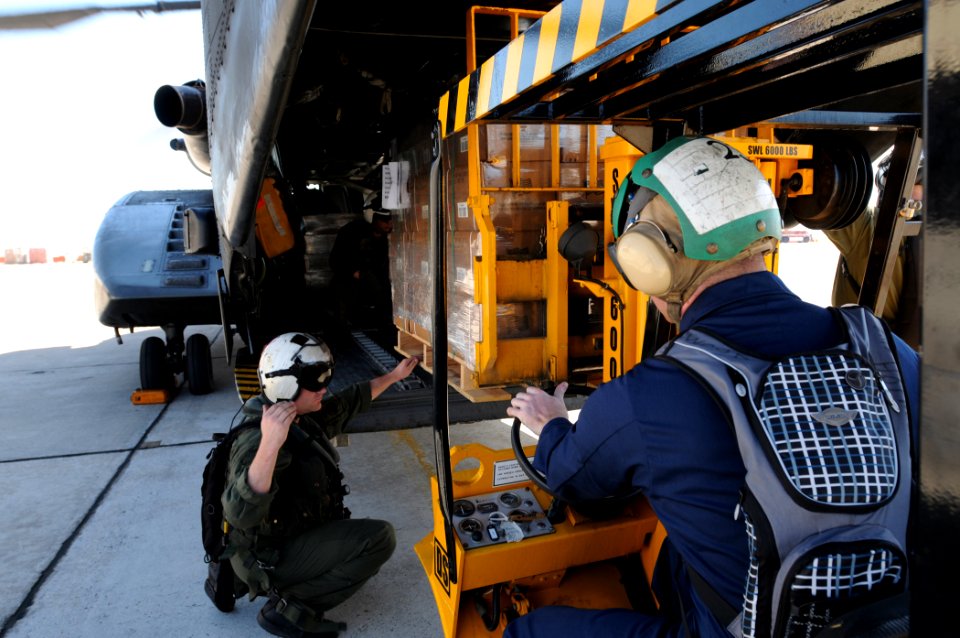 US Navy 100122-N-7456N-048 Naval Air Crewman 2nd Class Stephen Brant loads boxes of meals-ready-to-eat onto an MH-53E Sea Dragon helicopter