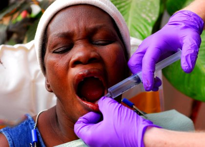 US Navy 100122-N-5244H-062 Lt. Joseph Reardon prepares a Haitian woman's gums for a tooth extraction at the Hope Estate Medical Clinic in Neply, Haiti photo