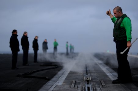 US Navy 100122-N-8907D-197 Aviation Boatswain's Mate (Equipment) Timothy Miller signals conditions ready during testing of the catapult system aboard the Nimitz-class aircraft carrier USS Harry S. Truman (CVN 75) photo