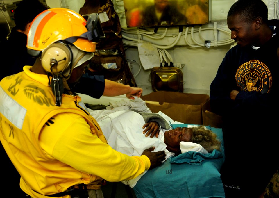 US Navy 100122-N-5345W-029 Chief Warrant Officer Wilfrid Bossous says goodbye to an elderly Haitian woman who was rescued after being trapped under rubble for seven days
