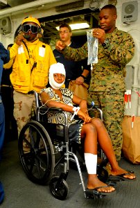US Navy 100121-N-5345W-005 An injured Haitian woman waits for a medical transport to USNS Comfort (T-AH 20) photo