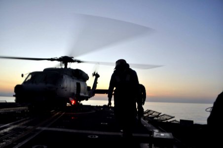 US Navy 100121-N-4124C-001 Boatswain's Mate Seaman Recruit Duimel J. Marquez, from Guatemala, runs back to the helicopter hangar of the guided-missile cruiser USS Normandy (CG 60) after placing a chock and chain on an SH-60B Se