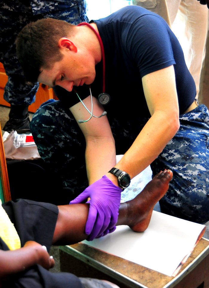 US Navy 100123-N-4774B-228 Chief Hospital Corpsman Shawn Kirkpatrick, assigned to the guided-missile cruiser USS Normandy (CG 60), treats a Haitian woman