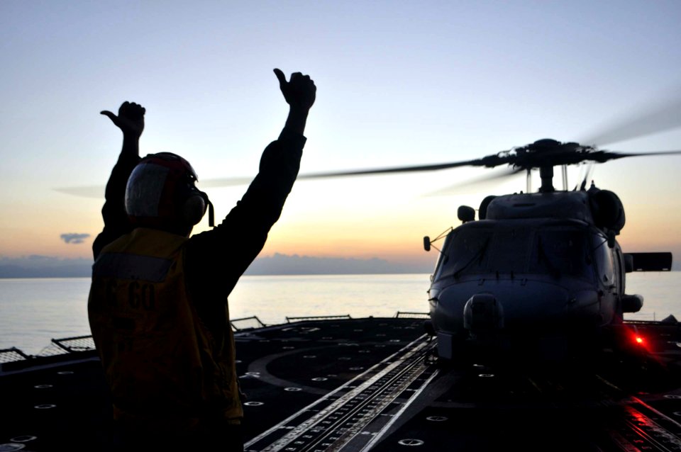 US Navy 100121-N-4124C-003 Boatswain's Mate Seaman Ruben Benders, from the Dominican Republic, signals an SH-60B Sea Hawk helicopter