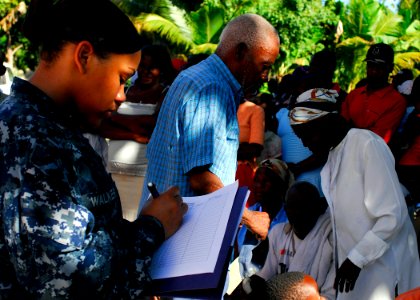 US Navy 100122-N-5244H-020 Yeoman 3rd Class Ashley Walker registers patients waiting to be seen at the Hope Estate Medical Clinic in Neply, Haiti photo