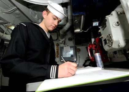 US Navy 100121-N-6233H-018 Boatswain's Mate 3rd Class Nate Long writes in the Petty Officer of the Watch logbook during his watch aboard the aircraft carrier USS George Washington (CVN 73)