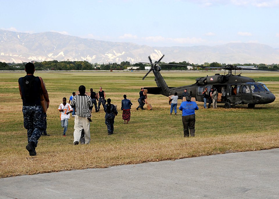 US Navy 100123-N-6247V-261 Haitian citizens and Sailors assigned to the Nimitz-class aircraft carrier USS Carl Vinson (CVN70) load boxes of food into helicopters