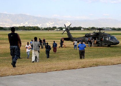 US Navy 100123-N-6247V-261 Haitian citizens and Sailors assigned to the Nimitz-class aircraft carrier USS Carl Vinson (CVN70) load boxes of food into helicopters