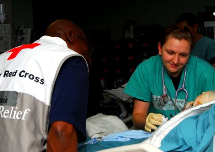 US Navy 100124-N-4047W-001 Lt. Lindsay Touchette cares for a burn victim in one of the intensive care unit wards aboard USNS Comfort (T-AH 20) photo