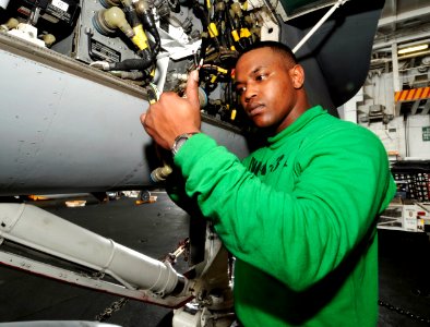 US Navy 100124-N-6003P-010 Sgt. Walter Walker, assigned to the Checkerboards of Marine Fighter Attack Squadron (VMFA) 312, inspects the wiring in the air data computer system of an F-A-18C Hornet aboard the Nimitz-class aircraf