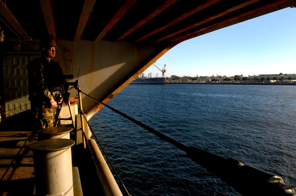 US Navy 100124-N-2475A-129 Information Systems Technician Omar Hernandez, from Los Angeles, stands security watch on sponson six as the Nimitz-class aircraft carrier USS John C. Stennis (CVN 74)