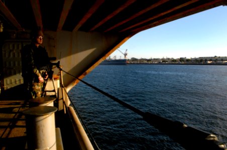 US Navy 100124-N-2475A-129 Information Systems Technician Omar Hernandez, from Los Angeles, stands security watch on sponson six as the Nimitz-class aircraft carrier USS John C. Stennis (CVN 74)
