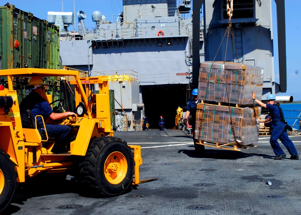 US Navy 100124-N-5244H-026 Sailors assigned to the amphibious dock landing ship USS Carter Hall (LSD 50) take on pallets of Meals-Ready-to-Eat