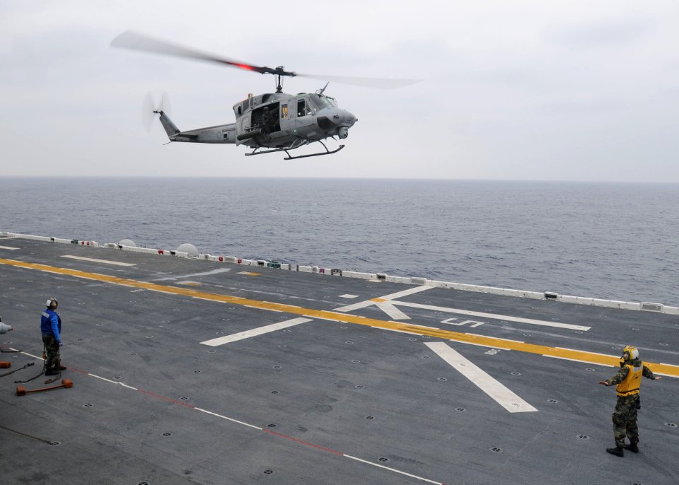 US Navy 100122-N-9950J-027 Aviation Boatswain's Mate (Handling) 3rd Class Patrick Neimeyer, from Montgomery, Ala., directs the landing of a UH-1N Huey helicopter aboard the forward-deployed amphibious assault ship USS Essex (LH