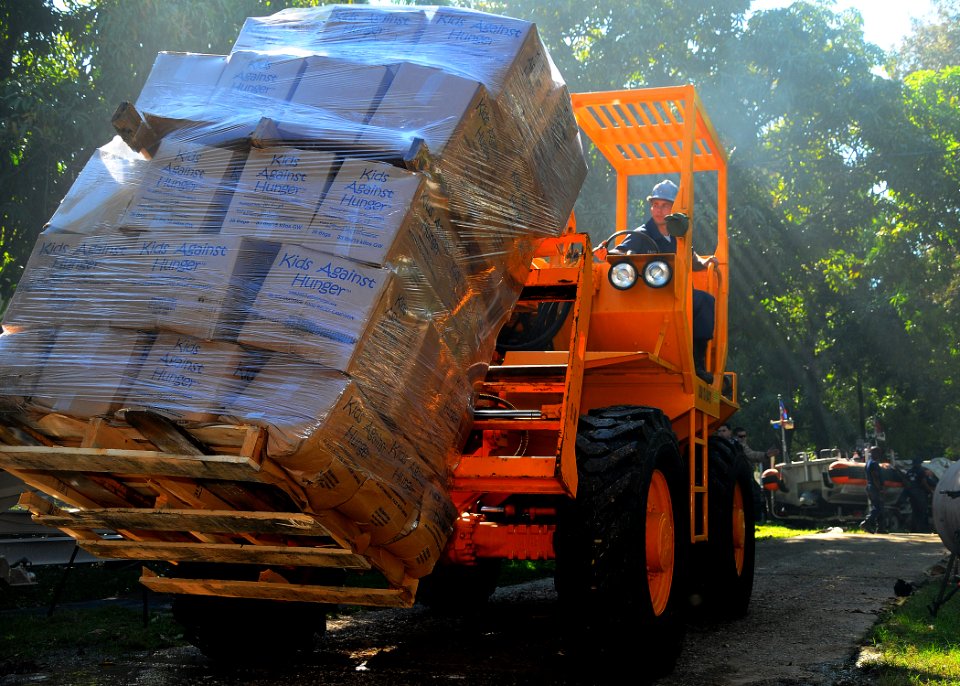 US Navy 100122-N-8655E-093 Boatswain's Mate Seaman Michael Sacco transports pallets of food provided through Project Handclasp