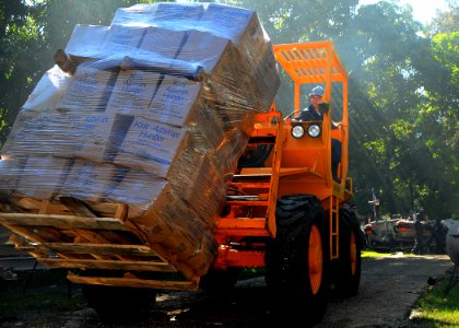 US Navy 100122-N-8655E-093 Boatswain's Mate Seaman Michael Sacco transports pallets of food provided through Project Handclasp
