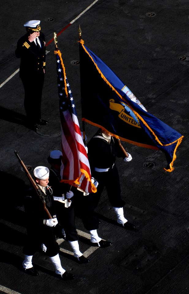 US Navy 100123-N-2475A-272 Presiding officer Cmdr. Mitchell Kloewer, top, from Albany, Ore., salutes as the color guard retire the colors at the end of a burial at sea ceremony onboard the Nimitz-class aircraft carrier USS Joh