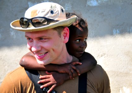 US Navy 100123-N-4774B-572 A Sailor assigned to the guided-missile cruiser USS Normandy (CG 60) carries a Haitian child during a site assessment